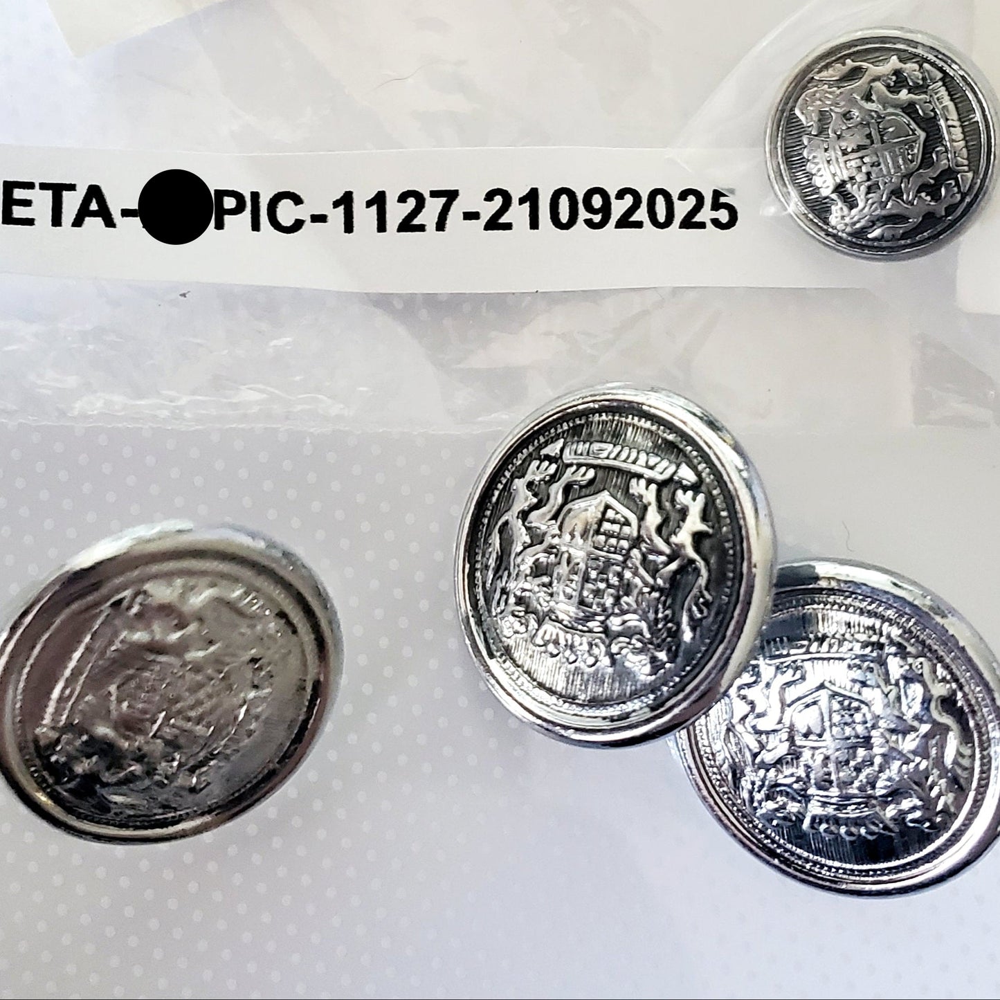 Silver colored shank style sewing buttons made from metal and emblem print